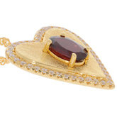 Oval red garnet heart pendant set in gold with sparkling moissanite accents, luxury jewelry piece for elegant style.